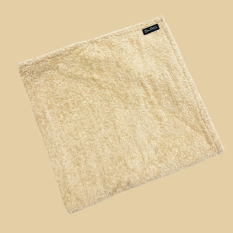 A folded cream pet towel with hand pockets, made from 100% cotton towelling, displayed on a white background.