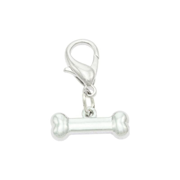 A silver-colored dog bone-shaped collar charm with a small bell attached to it.